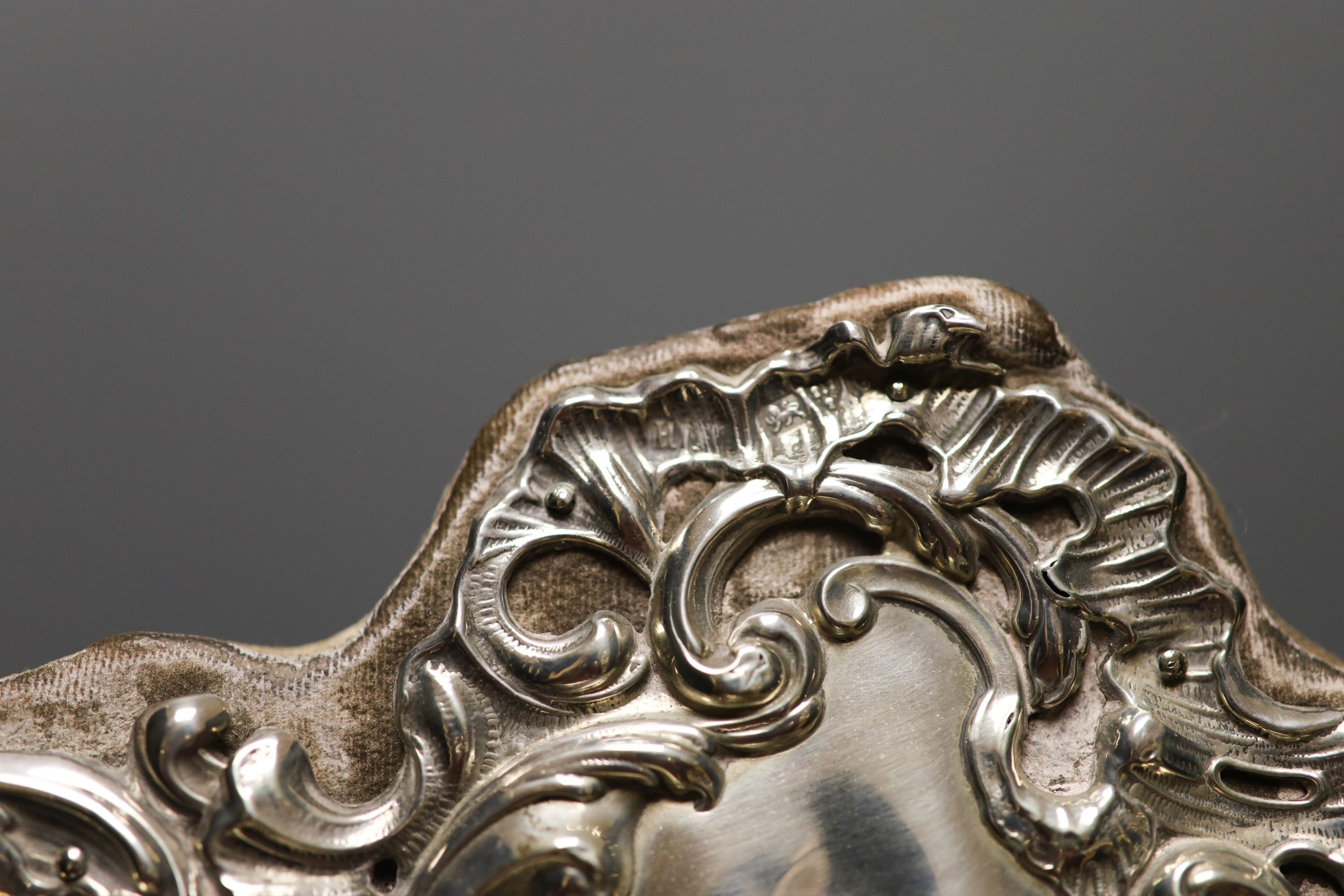 An Edwardian repousse silver mounted easel mirror, with foliate scroll decoration, Chester, 1902, height 45.7cm.